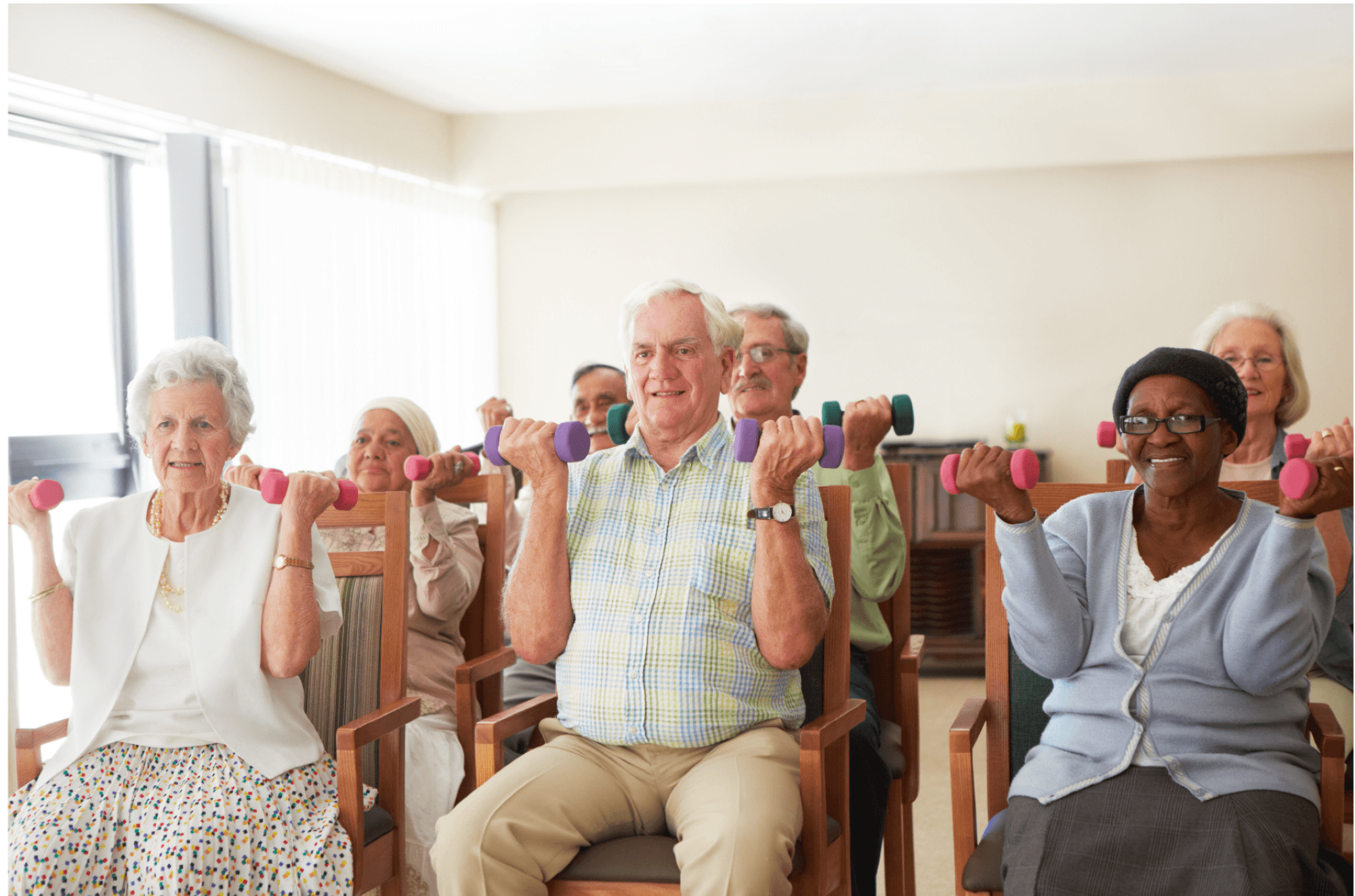 Older adults holding dumbbells in chair fitness class